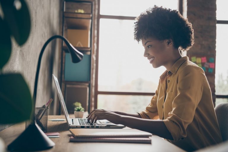 Profile side photo of smart cool afro american girl entrepreneur sit table use laptop work presentation in office loft workplace